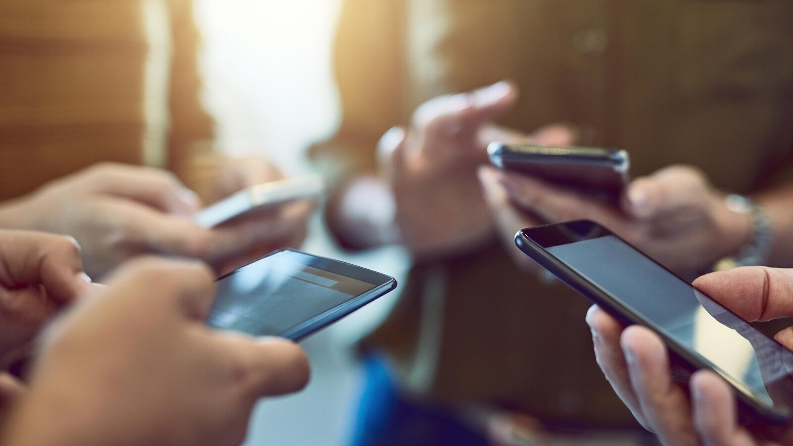 Un groupe de personnes en train d'utiliser leur cellulaire.