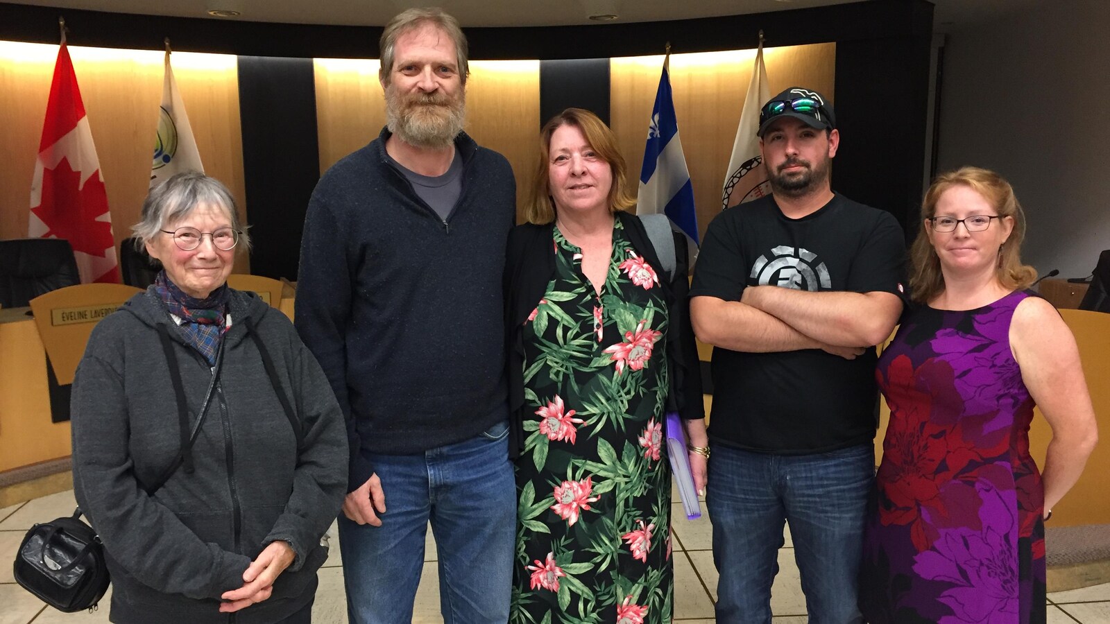 Cinq hommes et femmes sourient à la caméra dans le local du conseil municipal de Val-d'Or.