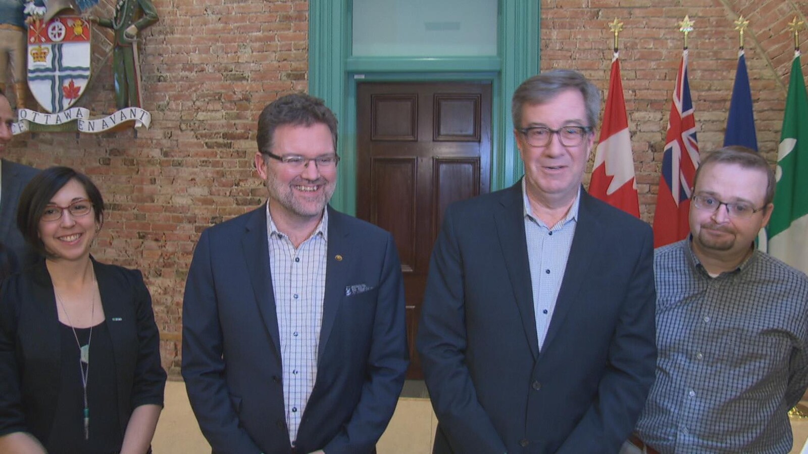 Les quatre personnes sont debout à l'extérieur du bureau du maire Jim Watson.