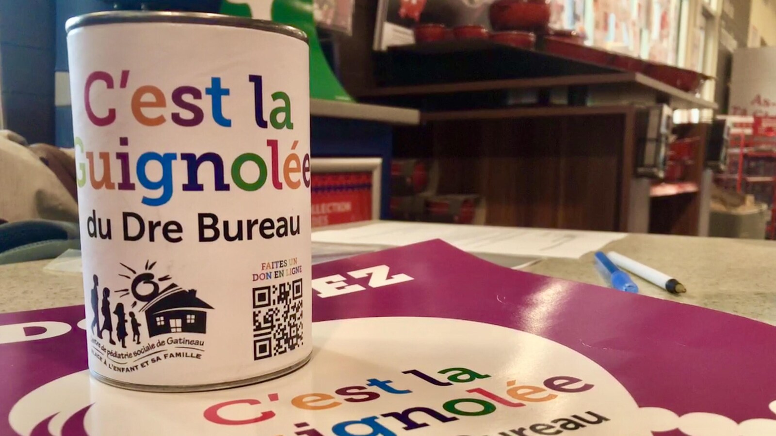 Une boîte de dons sur une affiche de la guignolée.