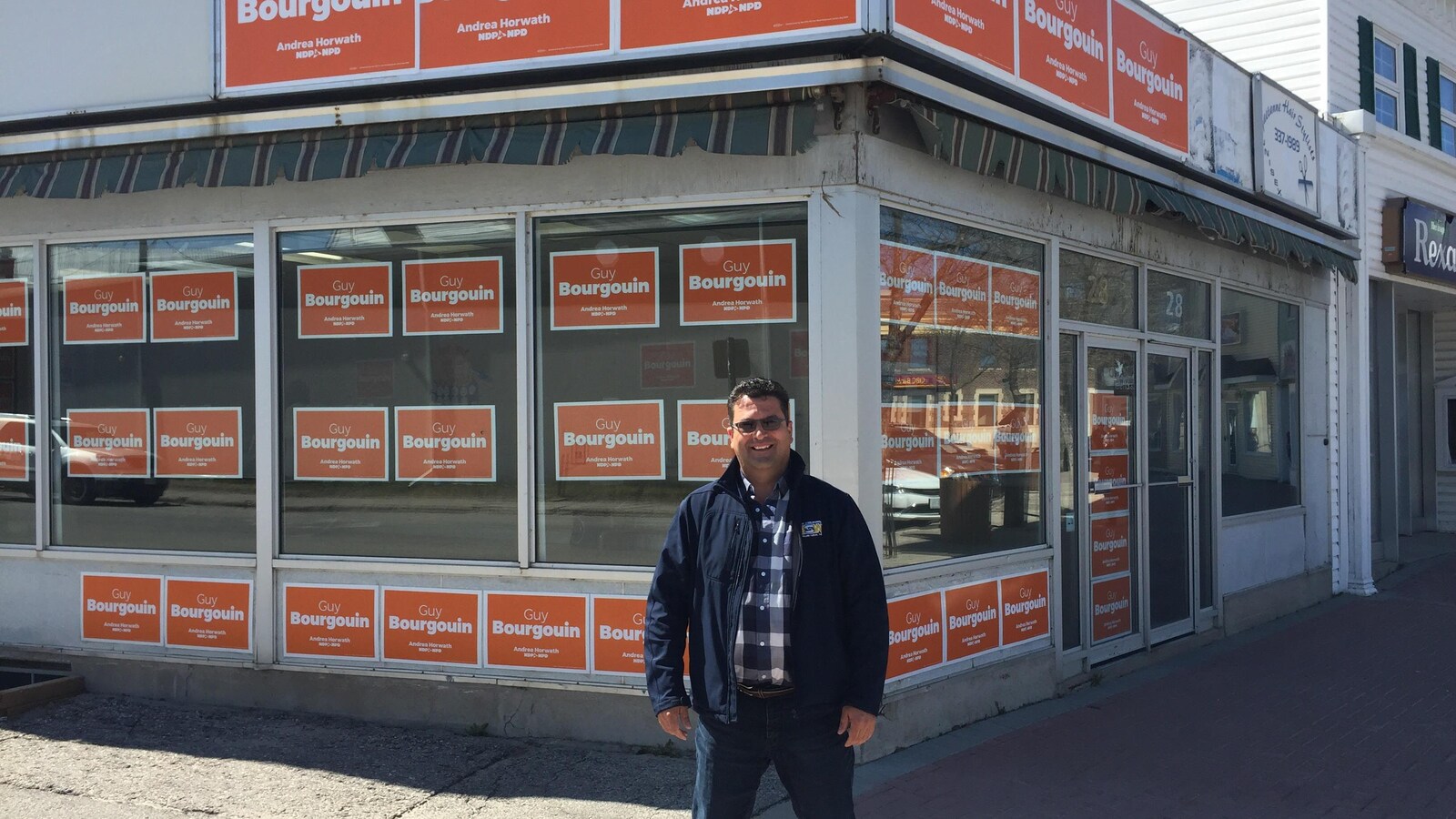 Un candidat néo-démocrate devant son bureau de campagne en Ontario.