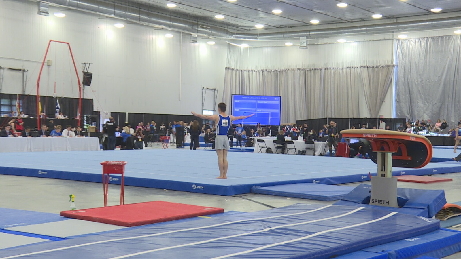 Un jeune homme durant une routine de gymnastique.