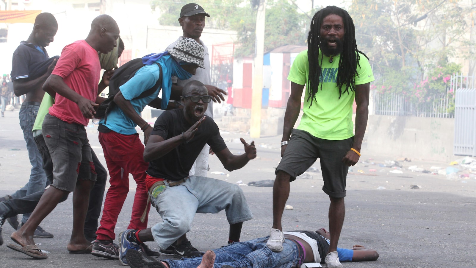 Des citoyens crient devant le corps d'un des leurs durant une manifestation contre le gouvernement à Port-au-Prince.
