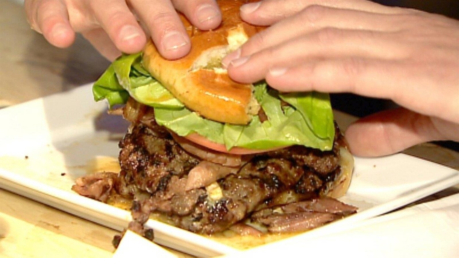 Des mains saisissent un hamburger