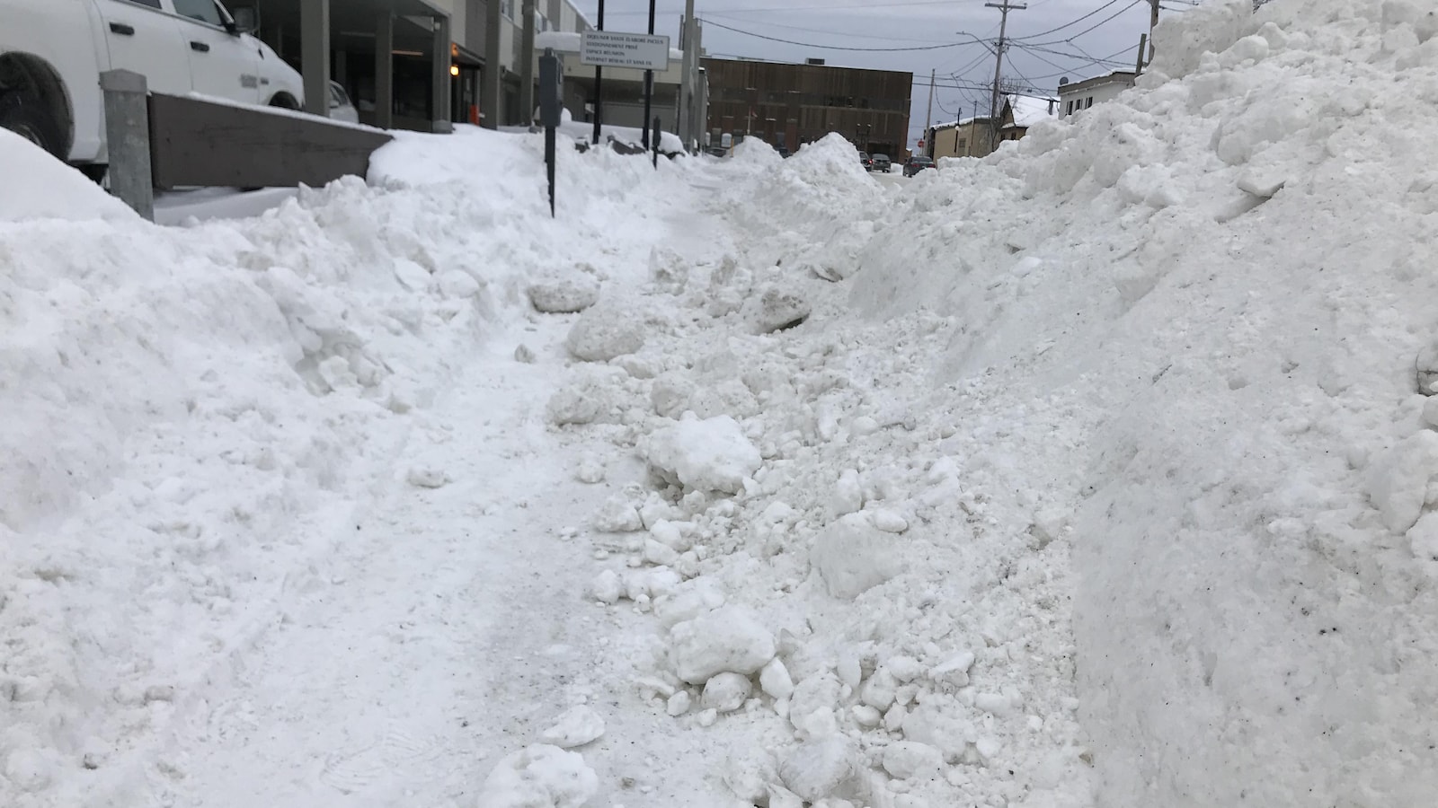 Un trottoir est rempli de blocs de neige.