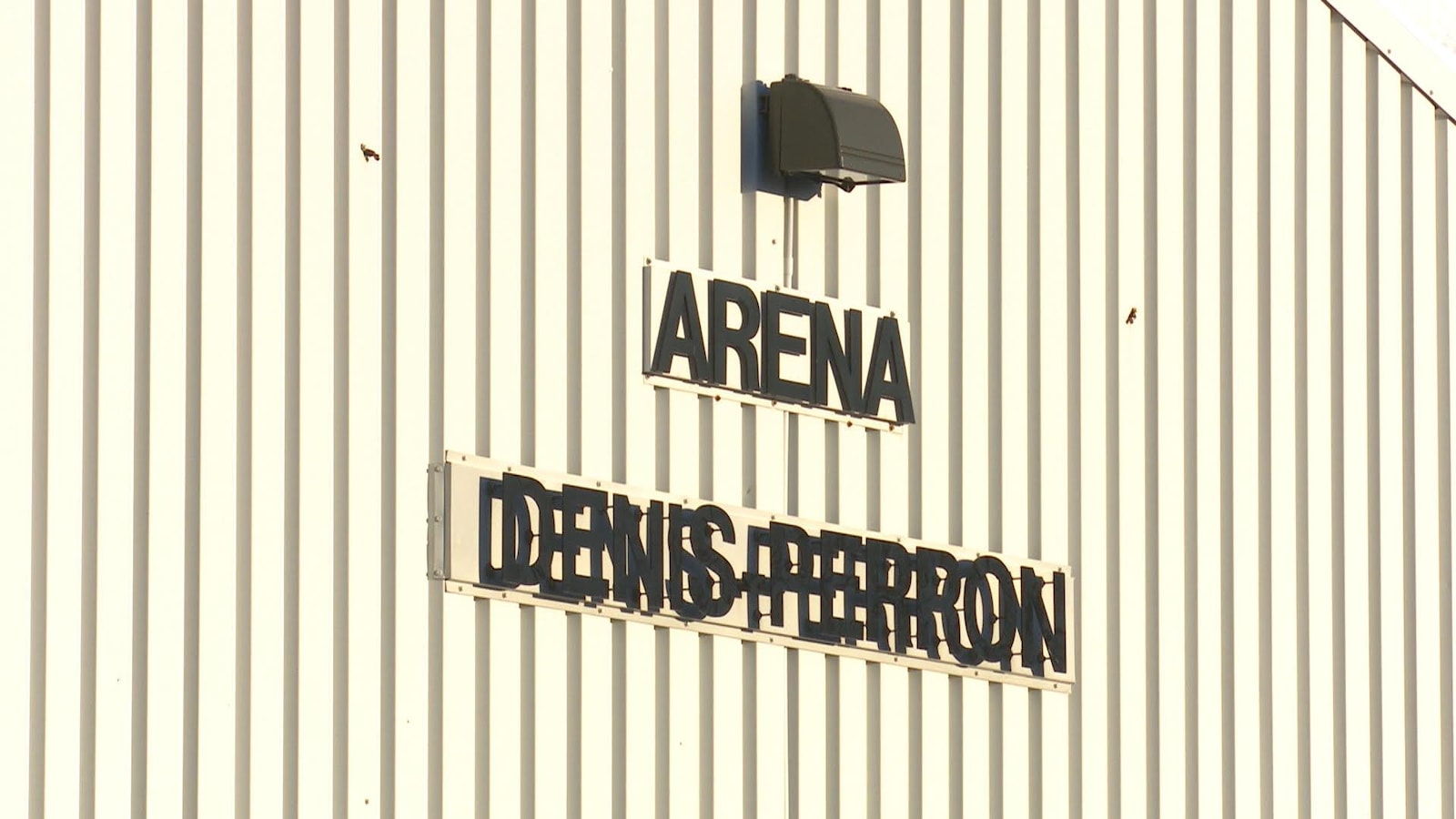 Sur un mur extérieur, on peut voir les mots Aréna Denis-Perron.