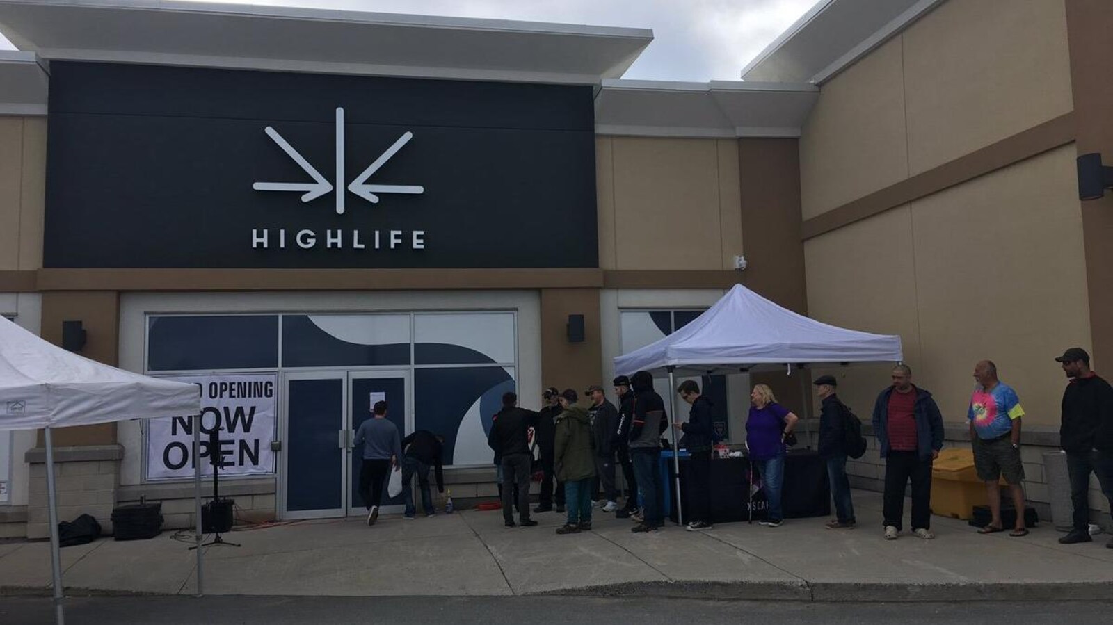Des gens en ligne devant un magasin.