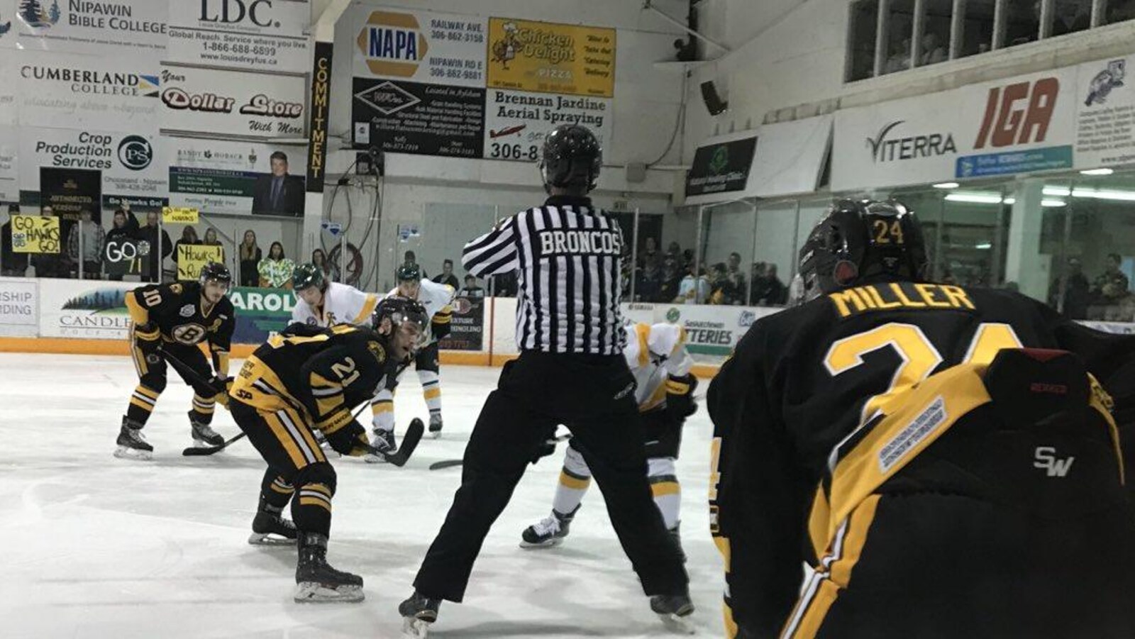 Des hockeyeurs des Bruins d'Estevan et les Hawks de Nipawin s'apprêtent à se lancer sur la rondelle samedi 14 avril 2018 dans un aréna en Saskatchewan