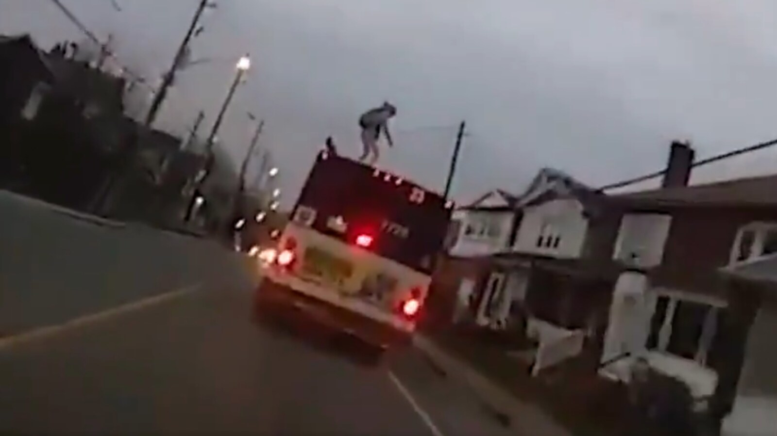 Photo d'un homme se tenant debout sur le toit d'un autobus de la CTT en mouvement.