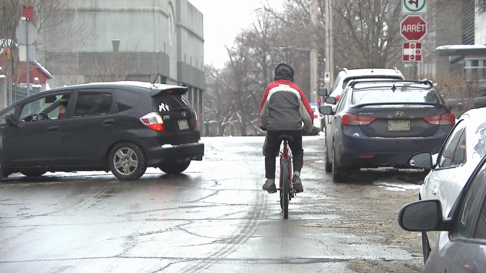 Homme à vélo dans une rue où il y a plein d'automobiles