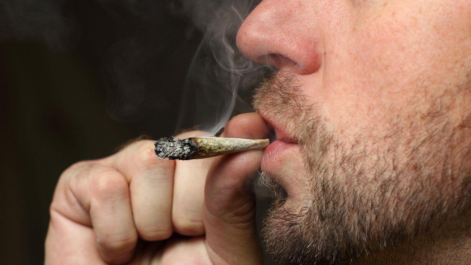 Un homme fume du cannabis.