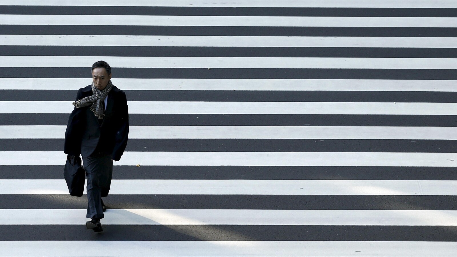 Un homme d'affaires traverse une rue à Tokyo.