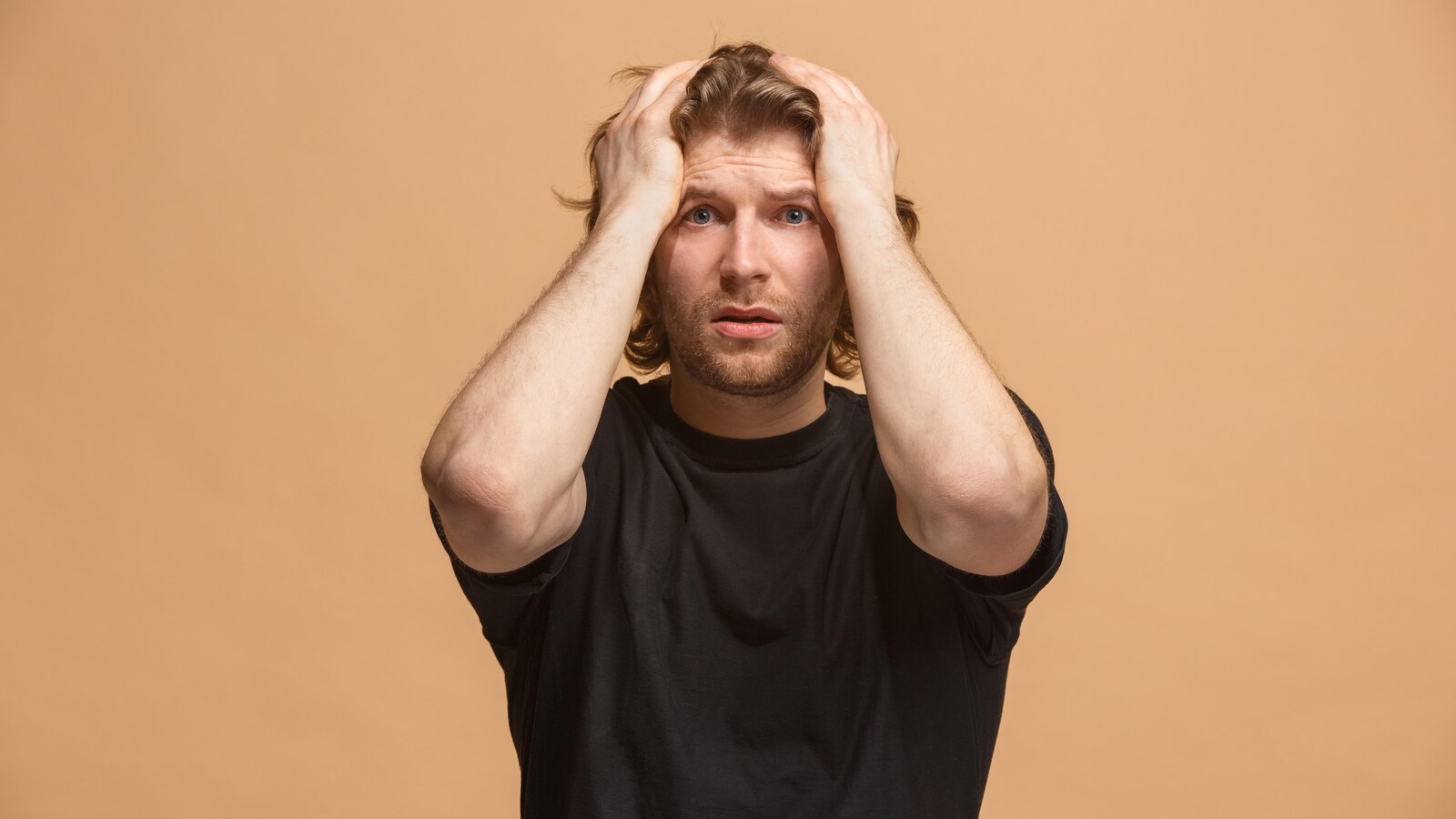 Un homme se tient les cheveux d'un air inquiet.