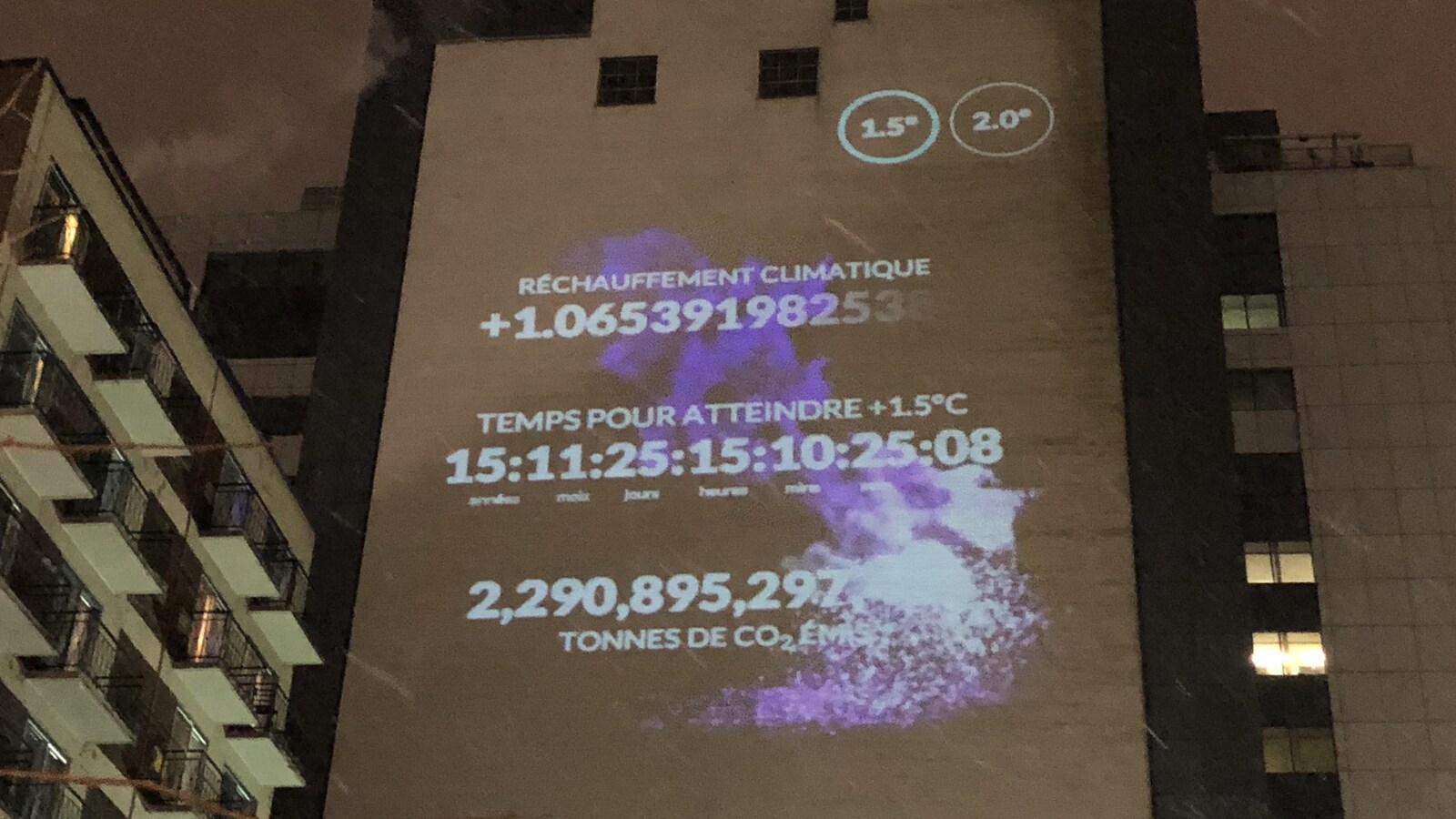 Données sur le réchauffement climatique projetées sur un édifice : réchauffement climatique, temps pour atteindre + 1,5 °C, tonnes de CO2 émises