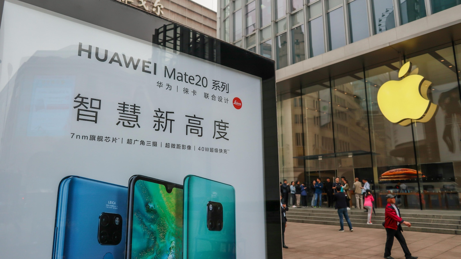 Un panneau publicitaire de Huawei est visible devant un magasin Apple dans une rue de Shanghai.