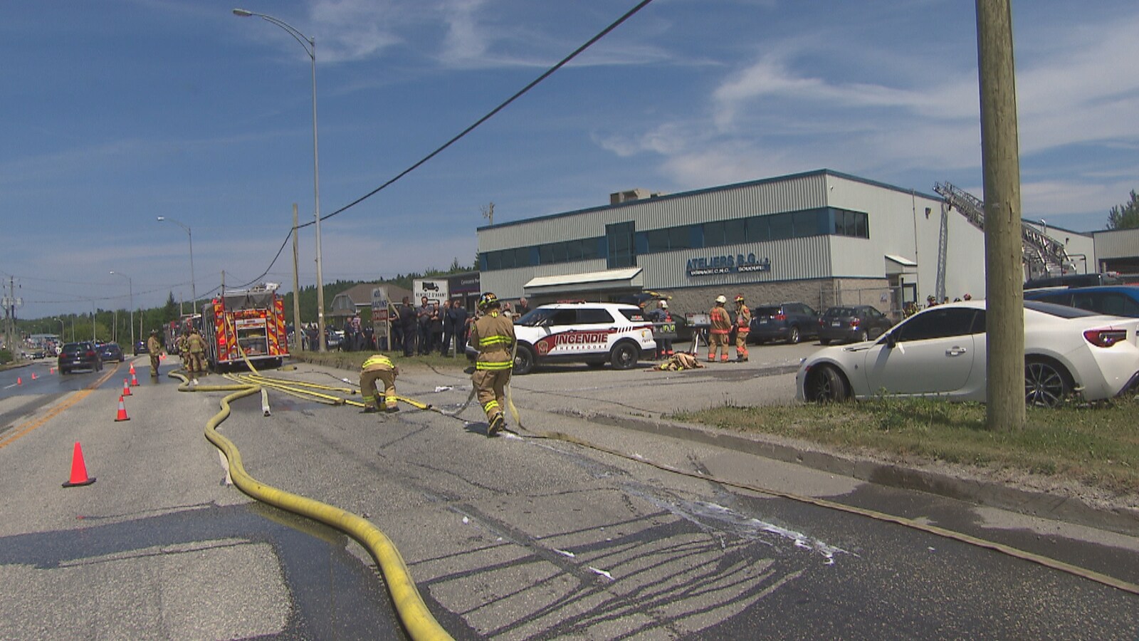 Les pompiers prennent des boyaux pour éteindre l'incendie.