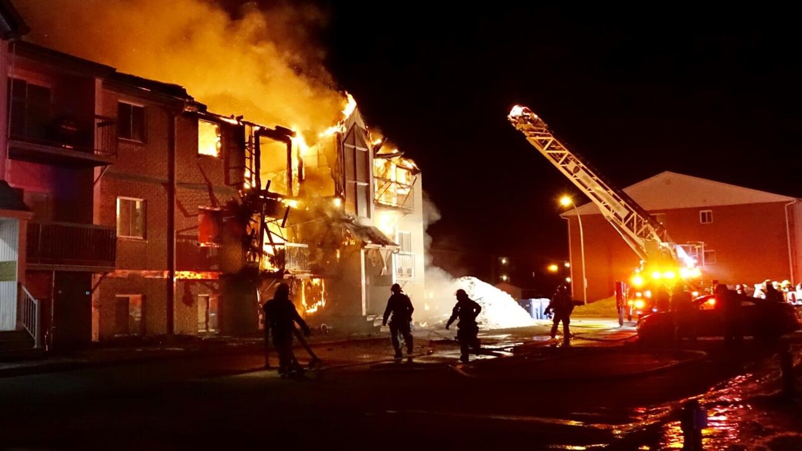 Des pompiers arrivent sur les lieux de l'incendie.