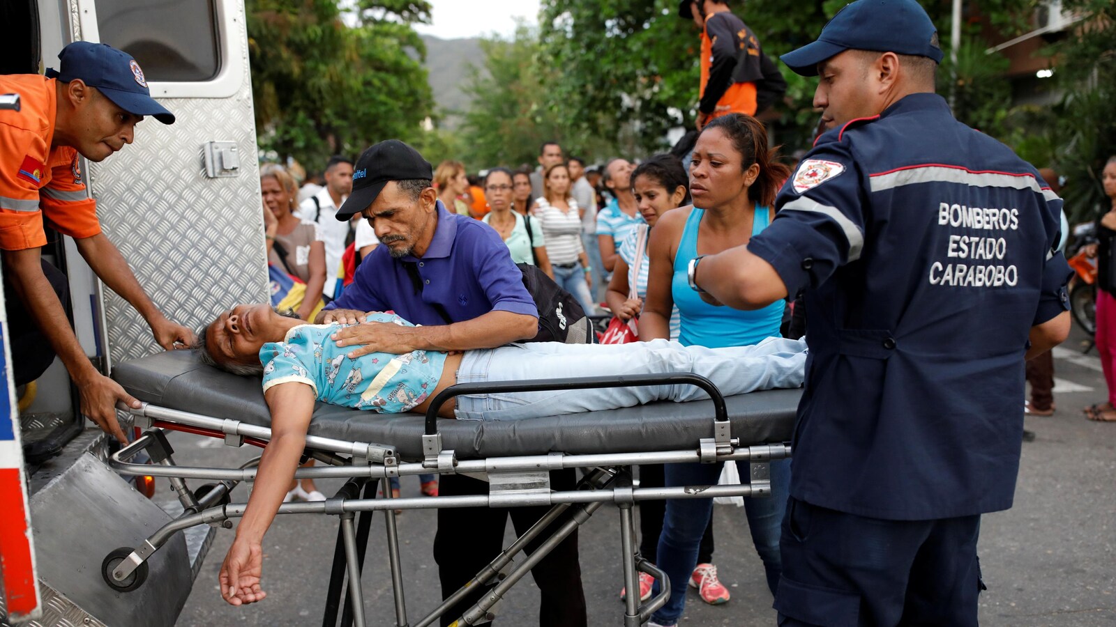 Des ambulanciers viennent en aide à une femme dont un proche est détenu au commissariat de la police de Carabobo, à Valencia au Venezuela, où un incendie a fait 68 morts le 28 mars 2018.