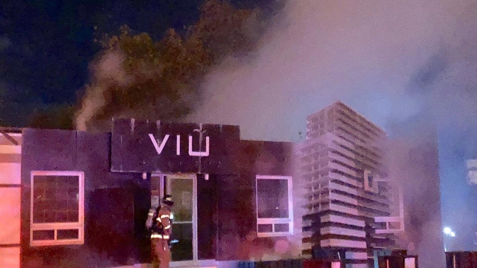Des pompiers s'affairant à combattre l'incendie dans le point de vente des condos VIU.