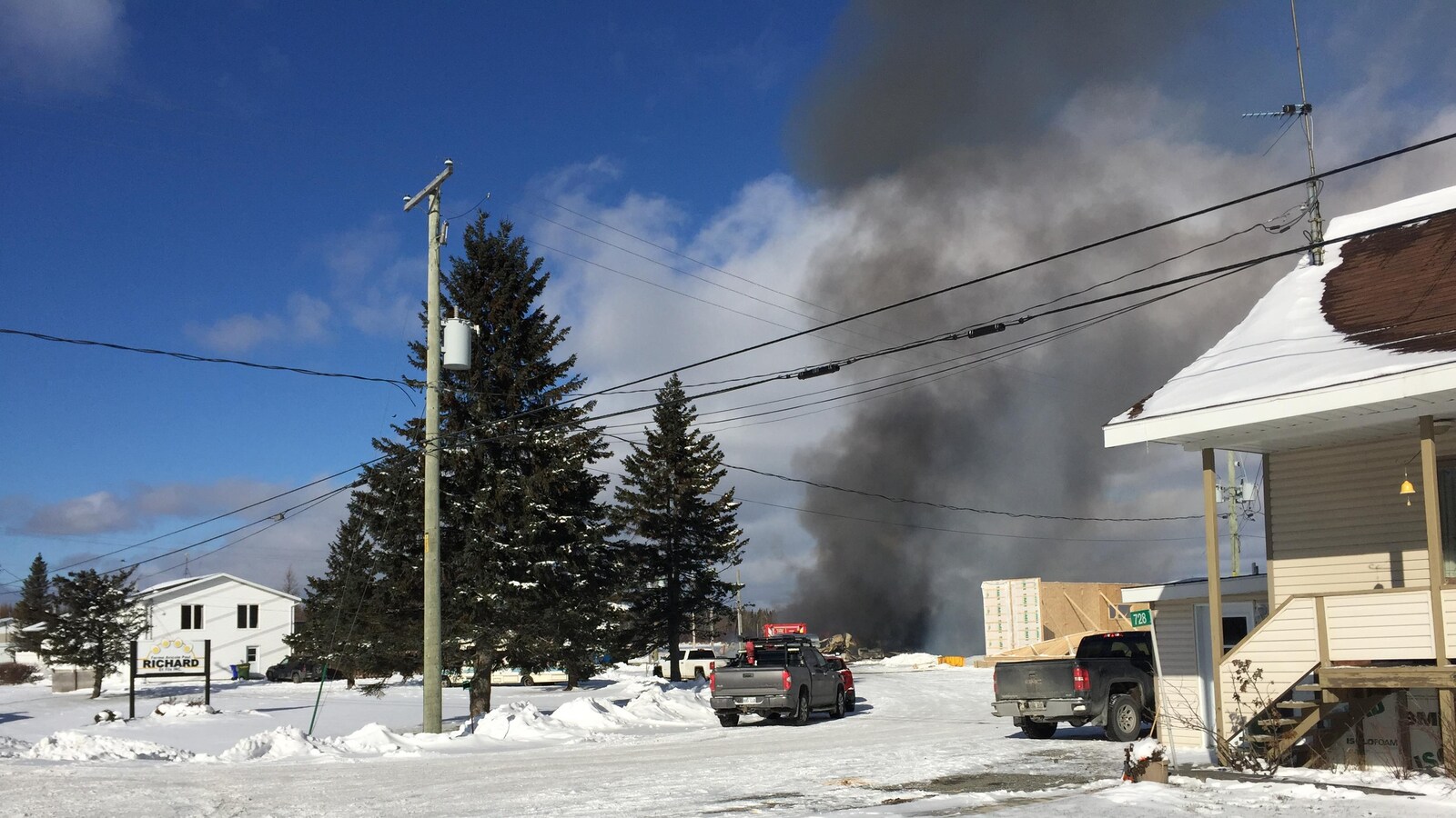 Un incendie dégage beaucoup de fumée sur une ferme, en hiver.