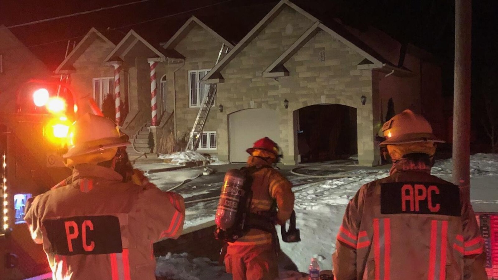 Des pompiers devant une résidence.