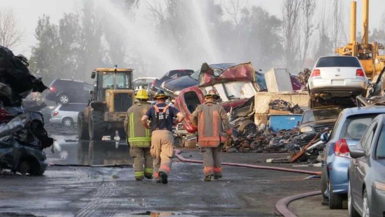 Des pompiers entourés de carcasses de voitures