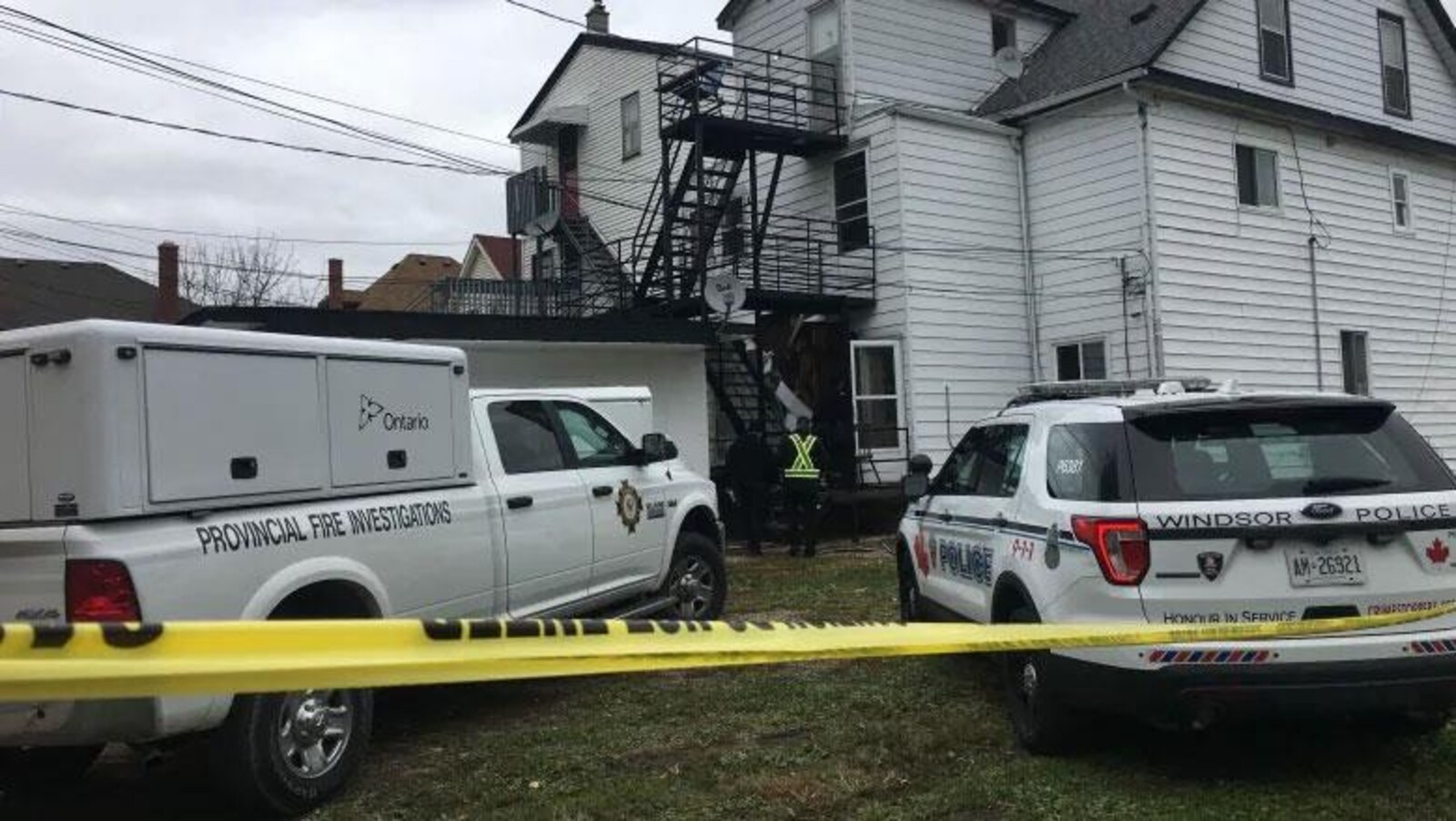Des véhicules de police et du gouvernement de l'Ontario garés devant une maison