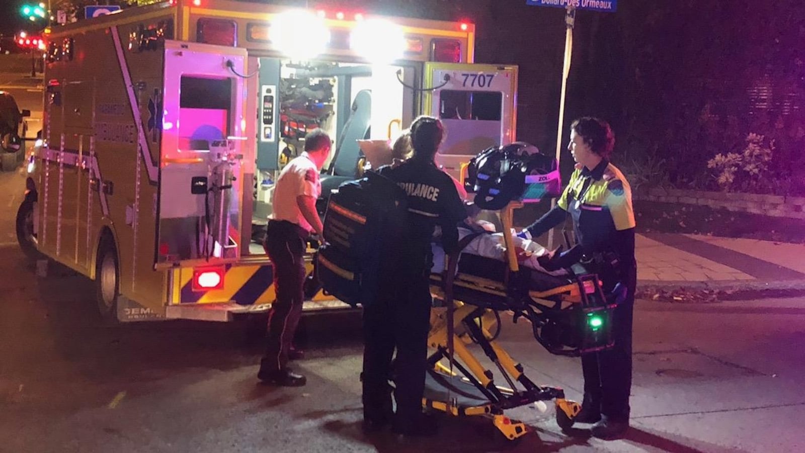 Une dame dans une civière alors qu'elle est placée dans une ambulance.