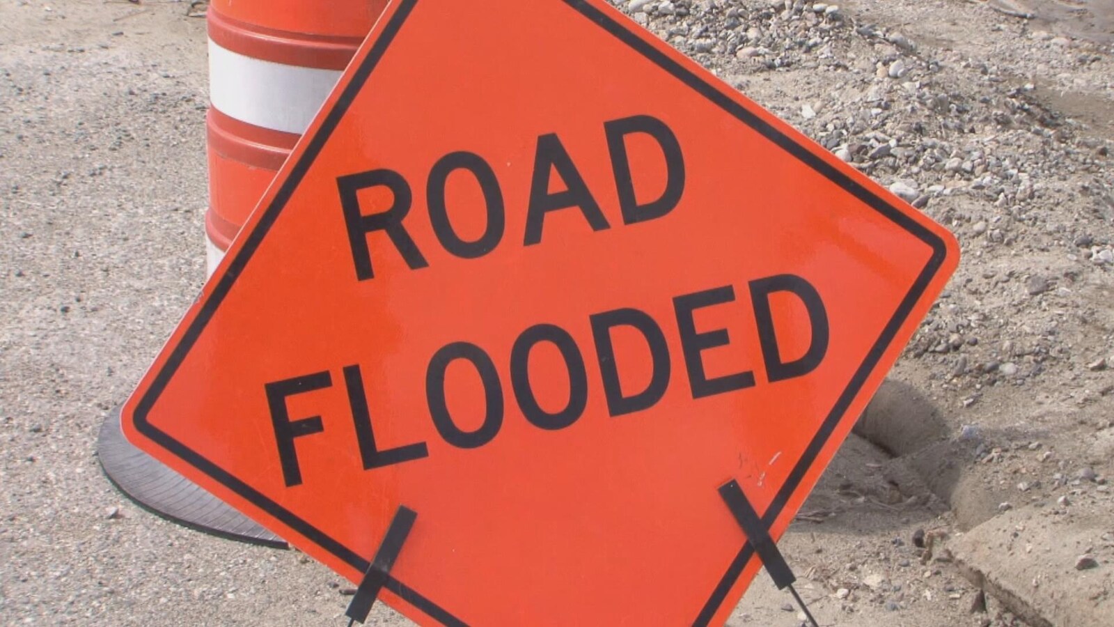 Une pancarte où il est inscrit road flooded, ce qui signifie route inondée.