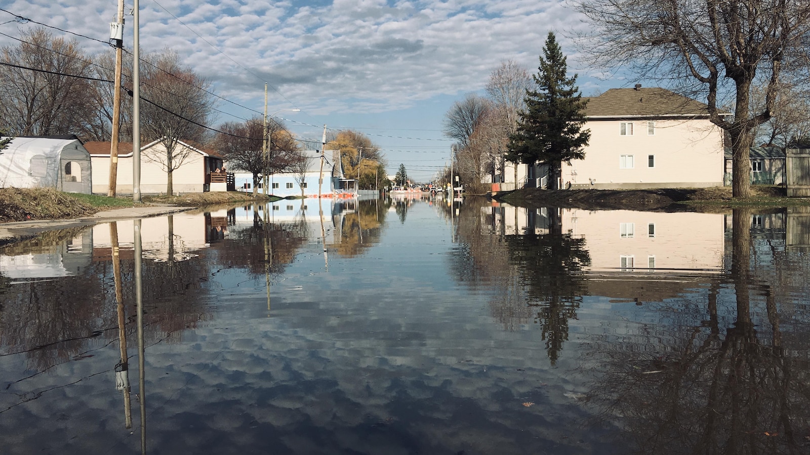 Les nuages se reflètent dans la rue entièrement inondée.