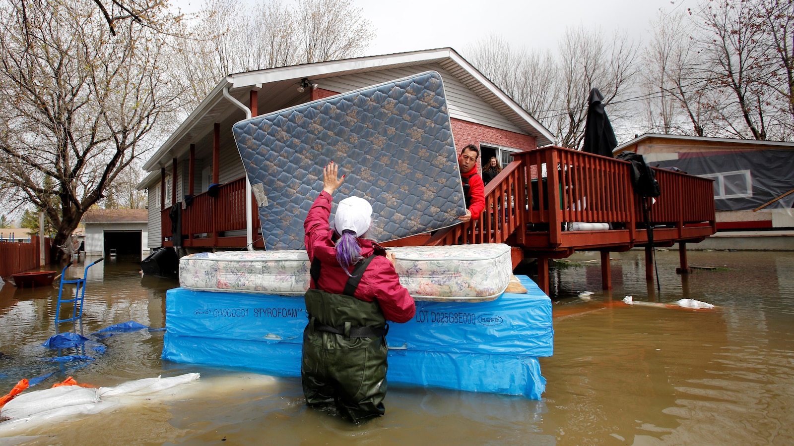Jean-François Perrault et Julie Theriault déplacent des matelas d'une résidence inondée d'une maison de Gatineau.