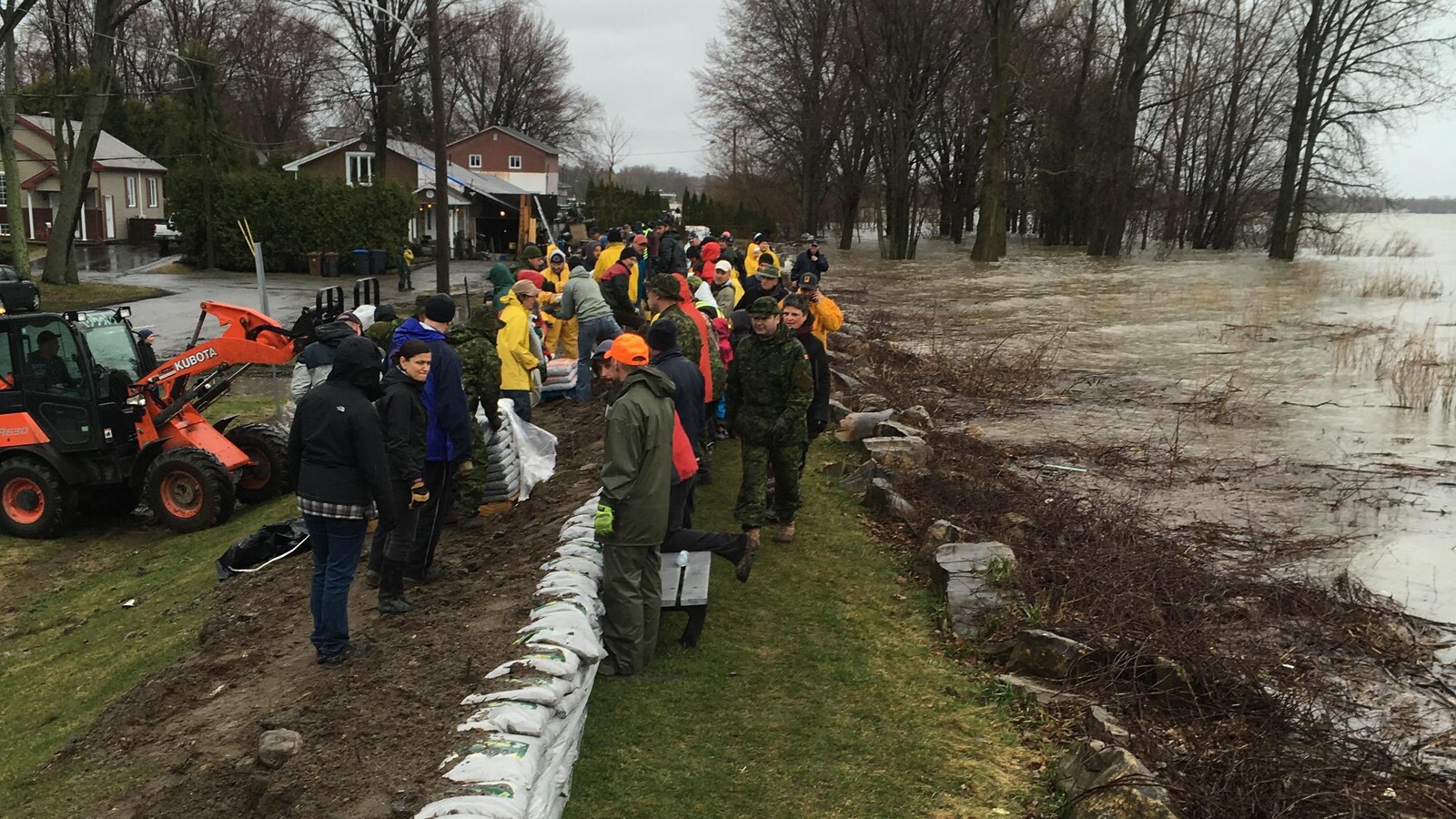 Des gens travaillent à renforcer une digue près de l'eau.