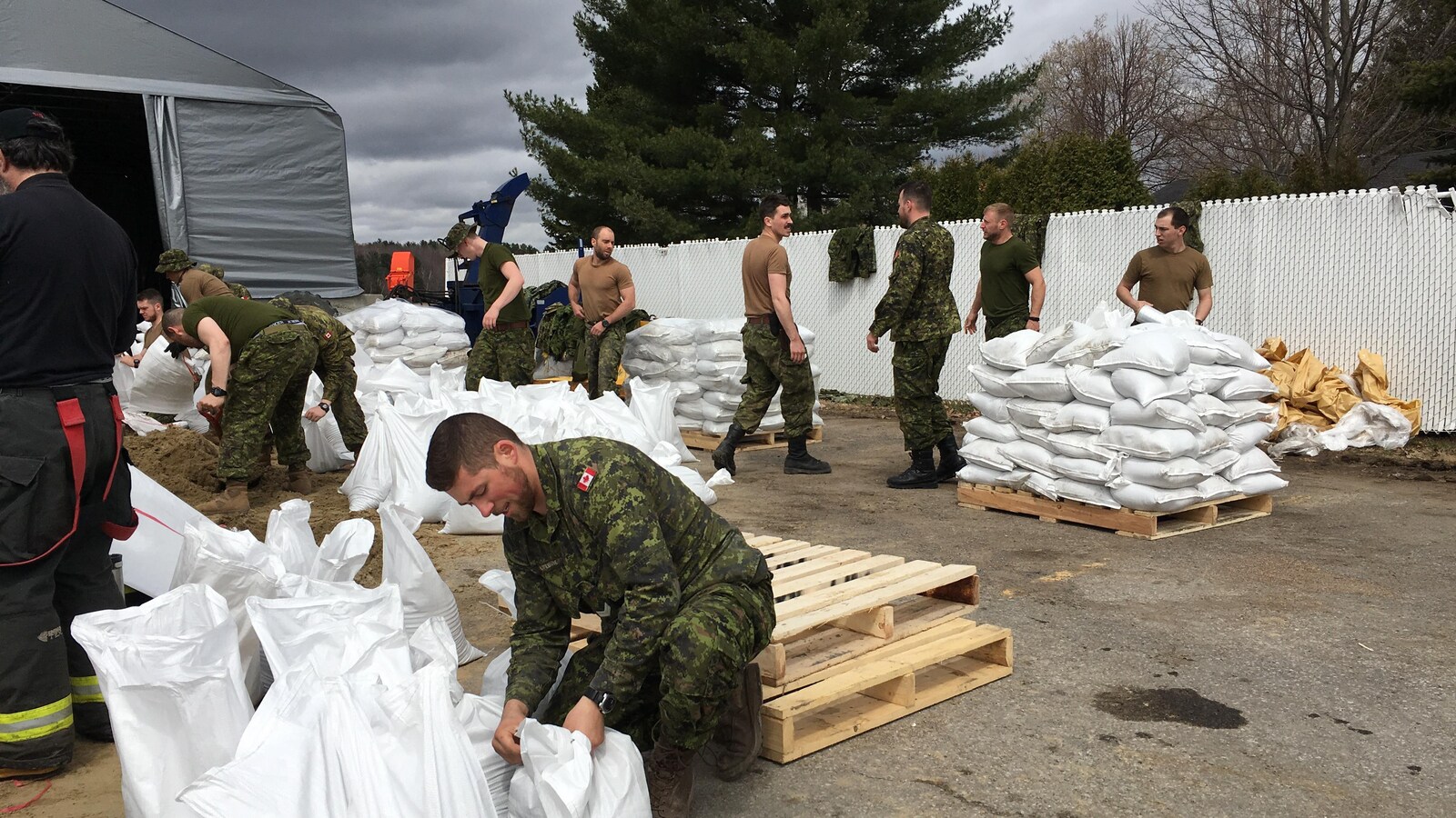 Des militaires préparent des sacs de sable.