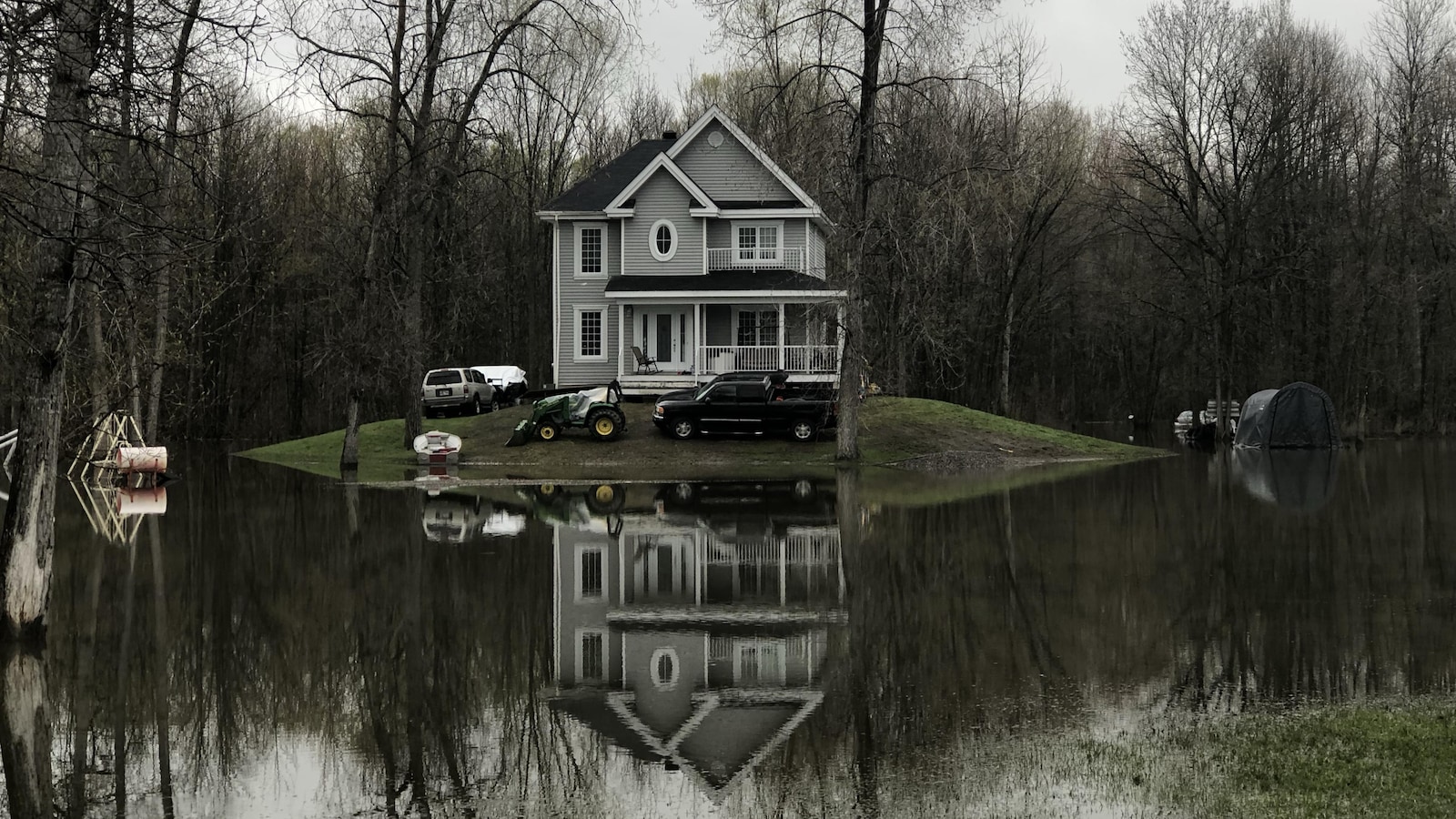 Une maison de deux étages sur une butte de terre entourée par l'eau