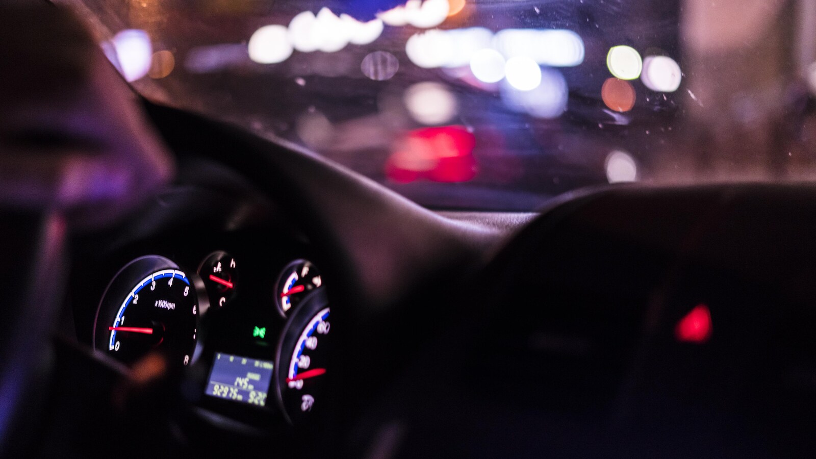 L'intérieur d'une voiture en marche, la nuit.