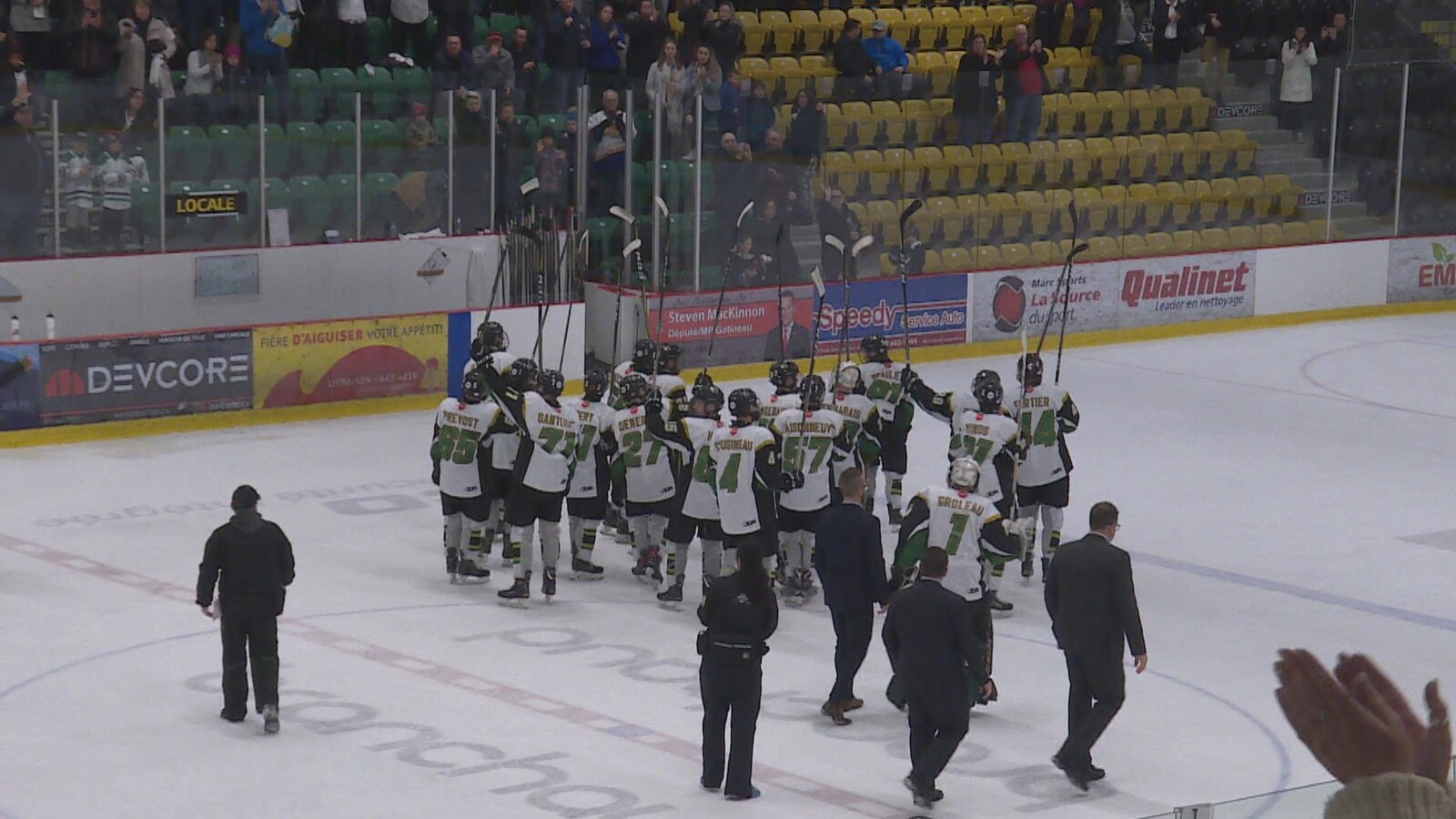 Des joueurs de hockey saluent la foule avec leur bâton.