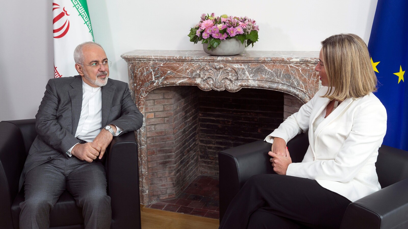 Assis dans des fauteuils, Mohammad Javad Zarif et Federica Mogherini se parlent.