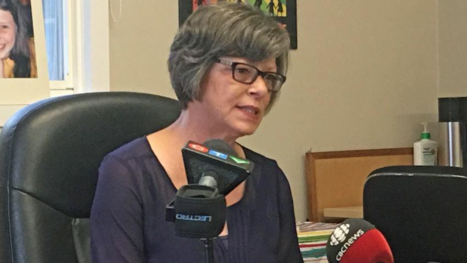 Une femme parle aux journalistes