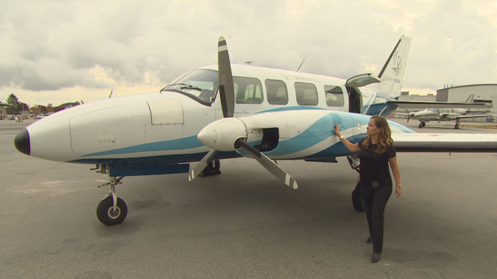 Teara Fraser debout à côté du premier avion de sa compagnie.
