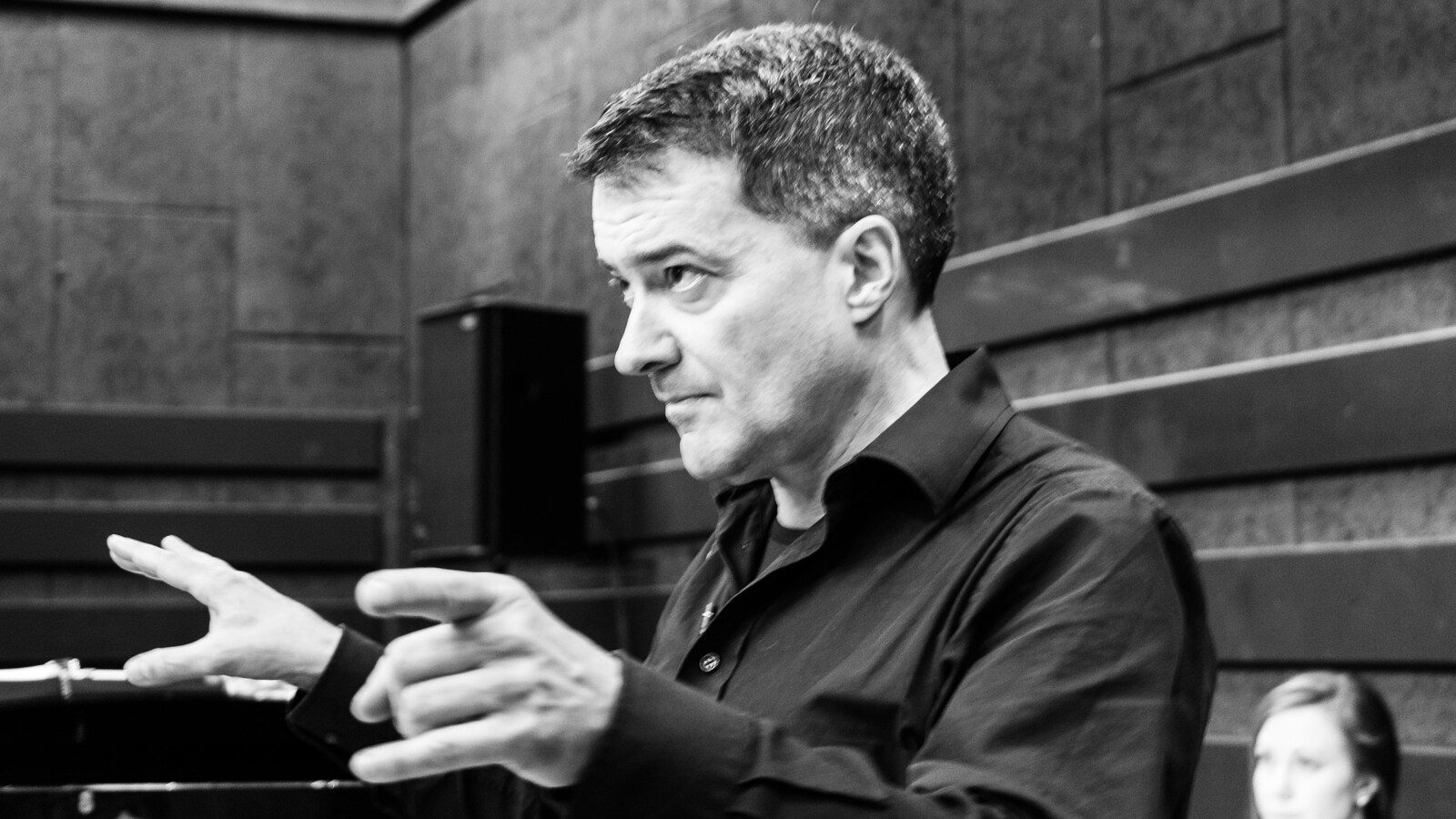 Jacques Lacombe de côté qui dirige des chanteurs