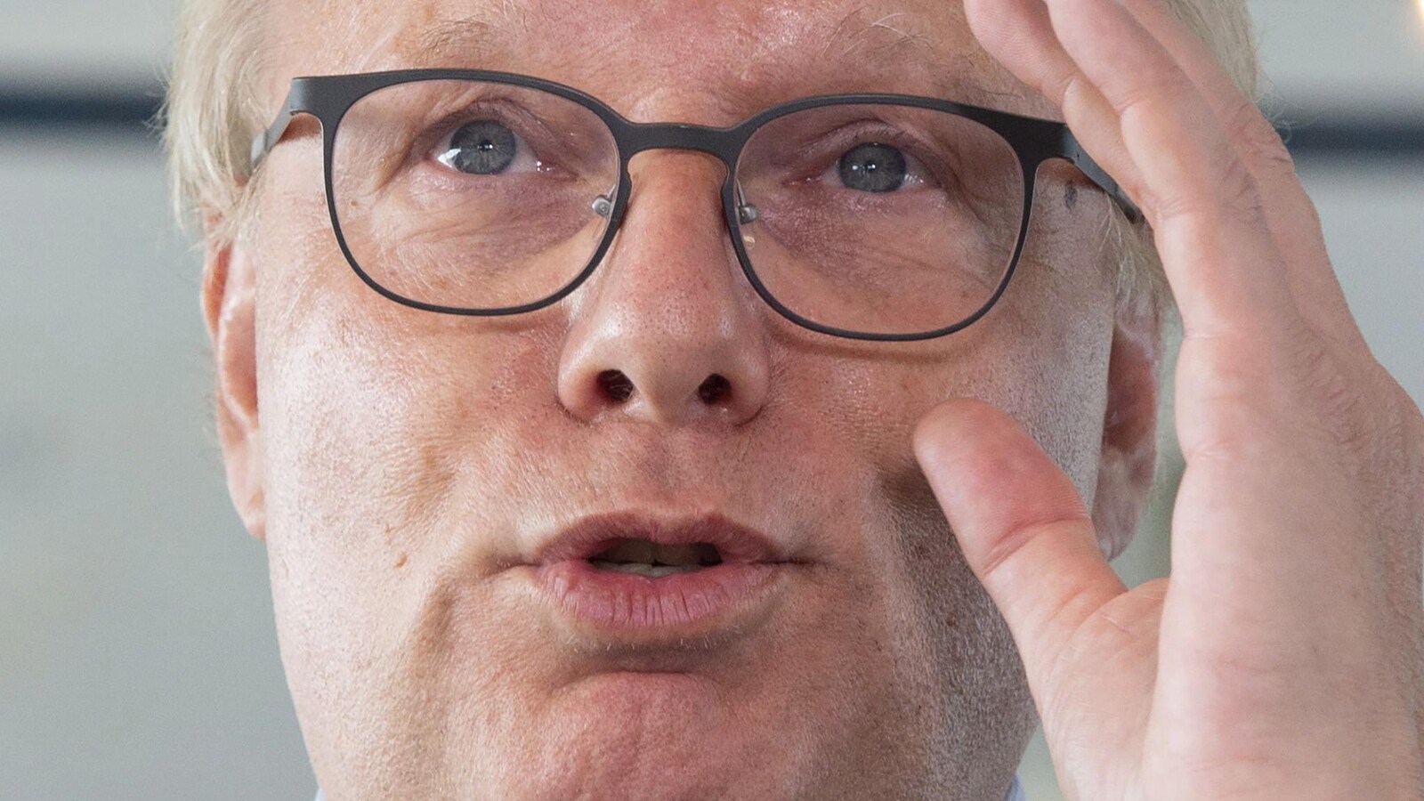 Le chef du Parti québécois, Jean-François Lisée, replace ses lunettes en parlant à des journalistes.