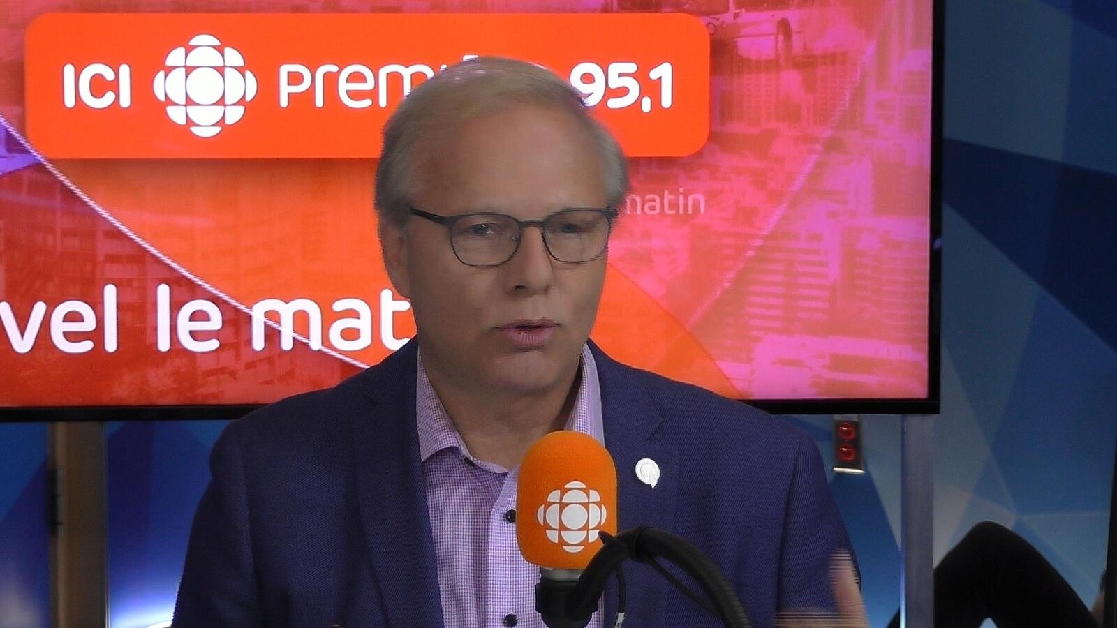 M. Lisée parle dans un micro dans un studio..