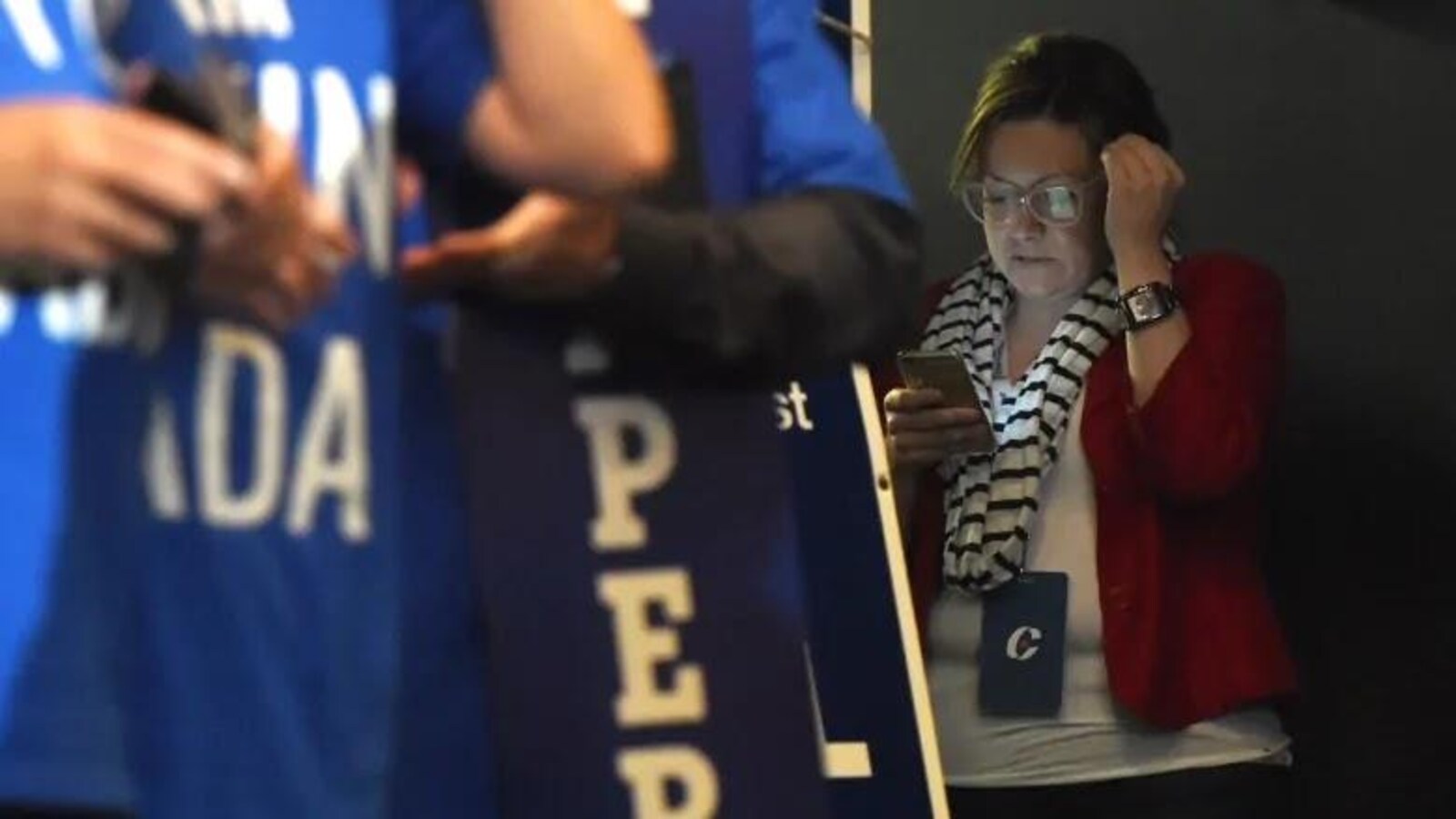 Une femme consulte son téléphone lors d'un rassemblement conservateur.