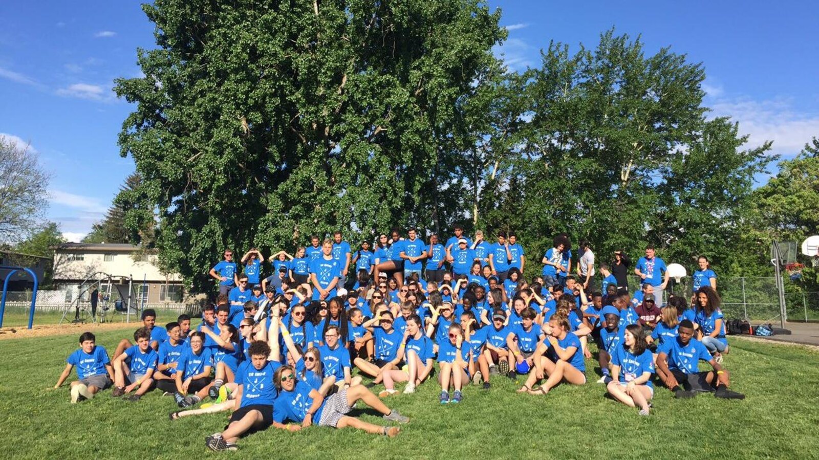 Des jeunes posent dans leur tenue de sport bleue.