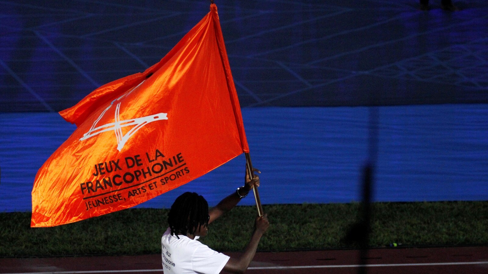 Ruth Marie Christelle Gbagbi, athlète de la Côte d'Ivoire en taekwondo, défile avec un drapeau des Jeux de la Francophonie.