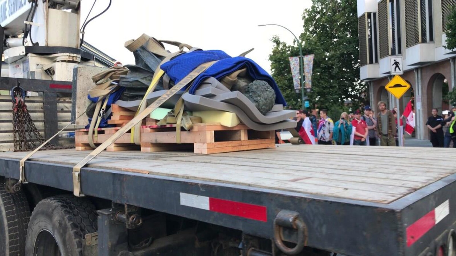 La statue de John A. Macdonald est enveloppée d'un tapis en polystyrène et allongée sur la remorque d'un camion à Victoria