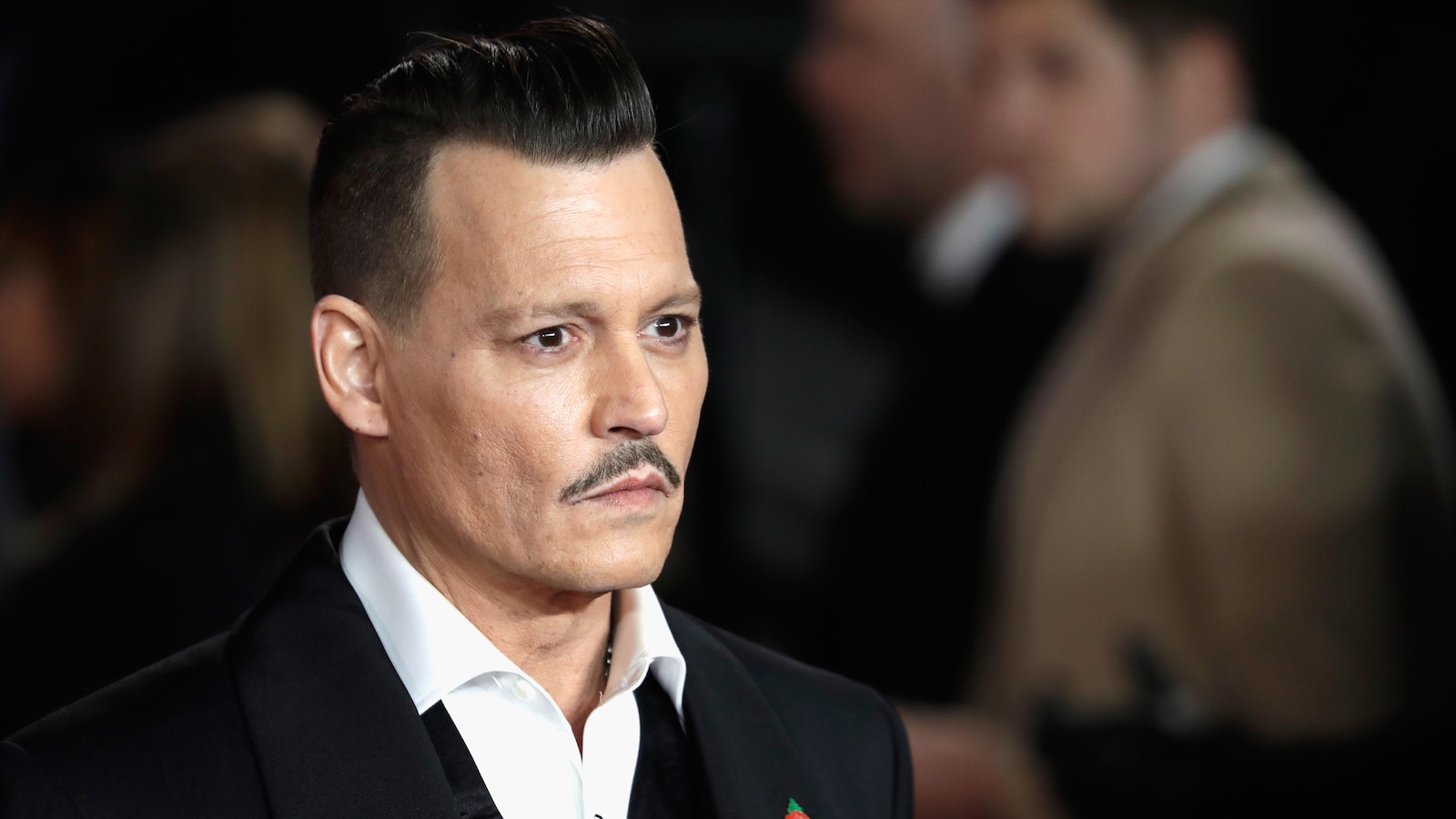 L'acteur Johnny Depp regarde au loin, alors qu'il prend la pose sur un tapis rouge, lors de la première d'un film.
