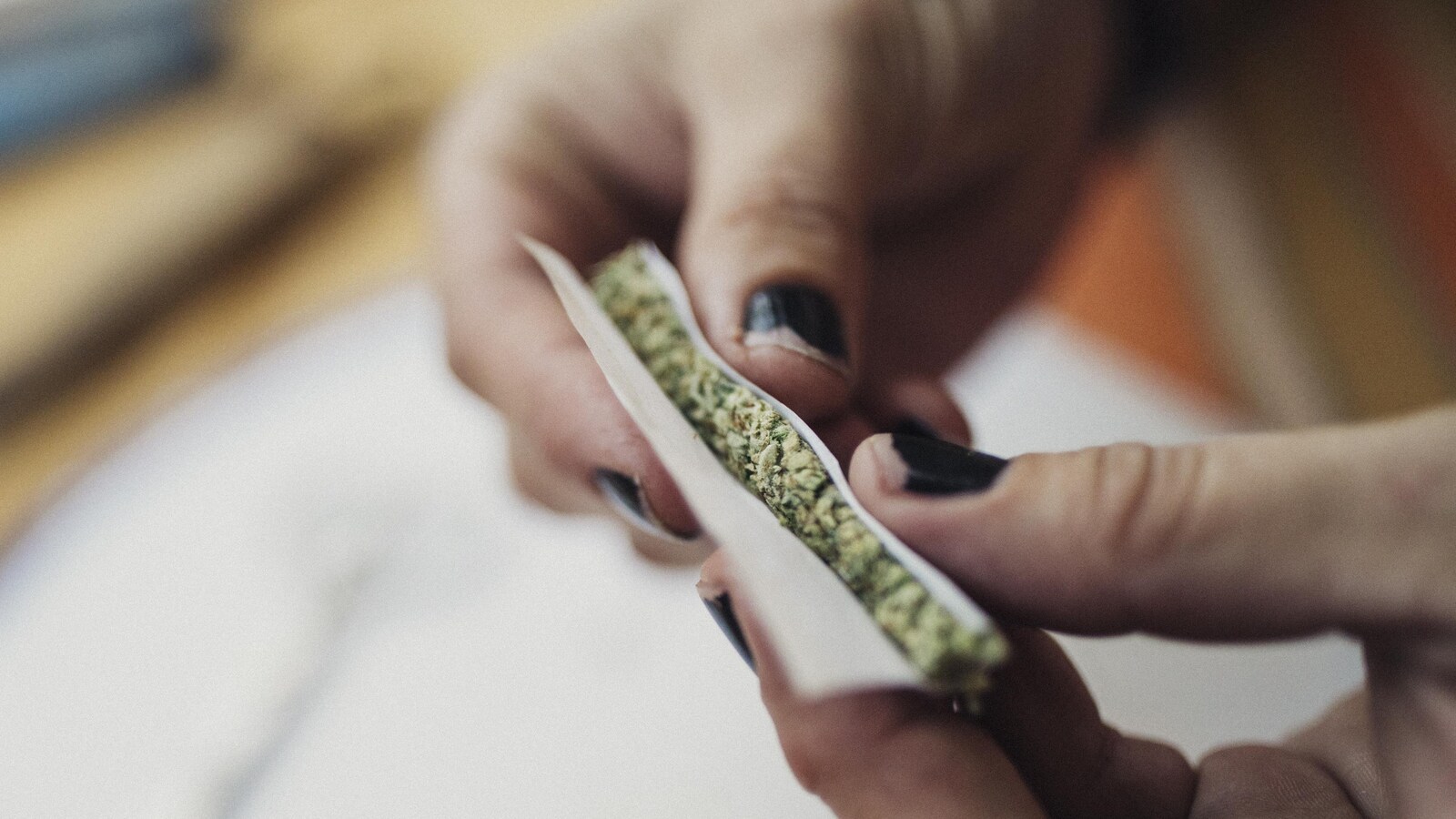 Gros plan sur les mains d'une femme qui roulent un joint