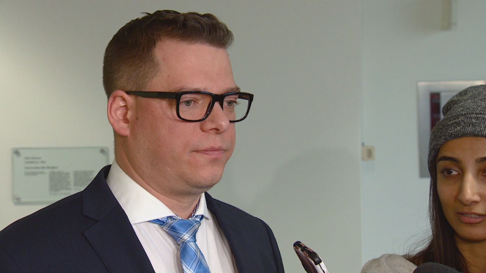 M. Dziadyk regarde devant lui d'un air sérieux pendant que des journalistes lui posent des questions.
