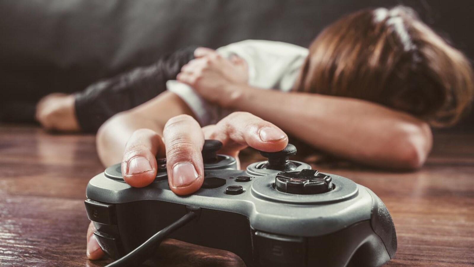 Une main sur une console de jeux vidéo.